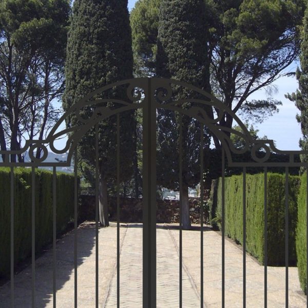 Valla con puerta y vista a un jardin
