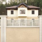 Valla y vivienda al fondo