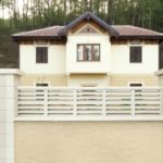 muro de una vivienda con Balaustre cerramiento con vivienda en el fondo
