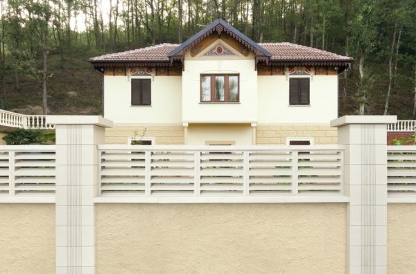 muro de una vivienda con Balaustre cerramiento con vivienda en el fondo